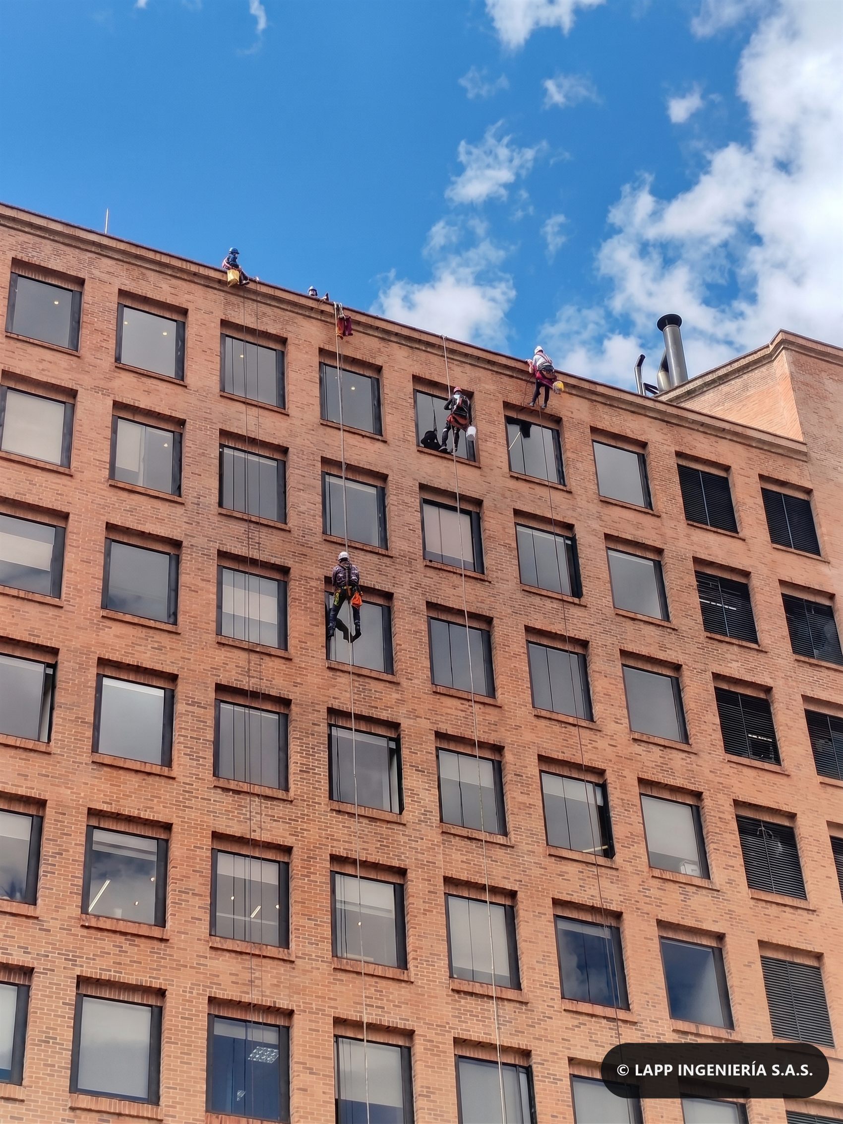 Personal certificado en altura sobre fachada de edificio